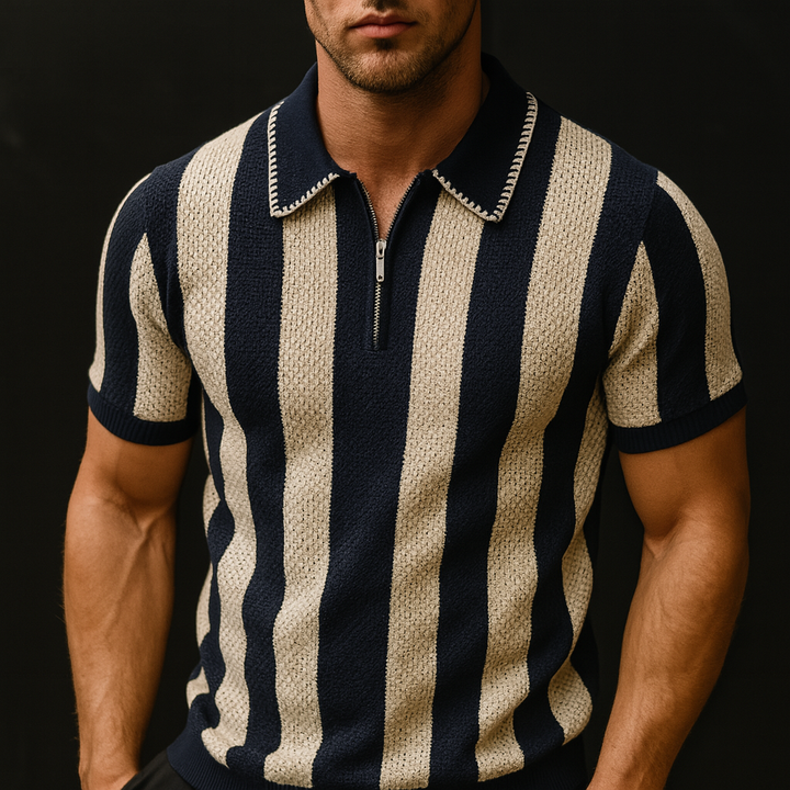 Man wearing a navy and beige striped knitted polo shirt against a black background